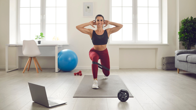 A woman does lunges at home