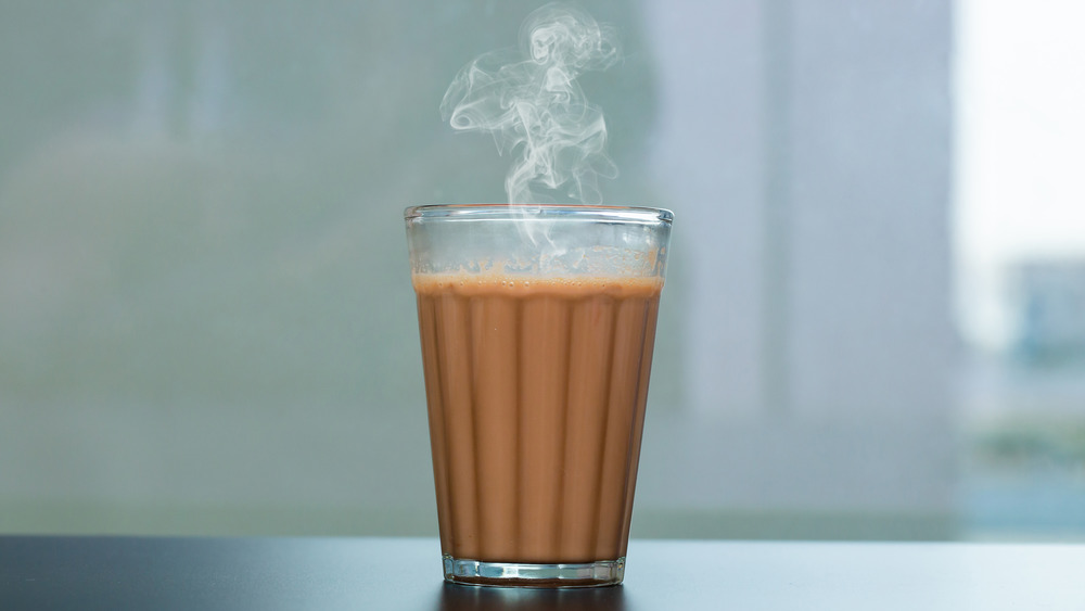 A steaming tea latte in a see through glass 