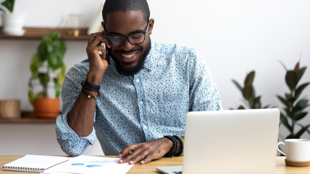 Man sitting at a desk talking on the phone