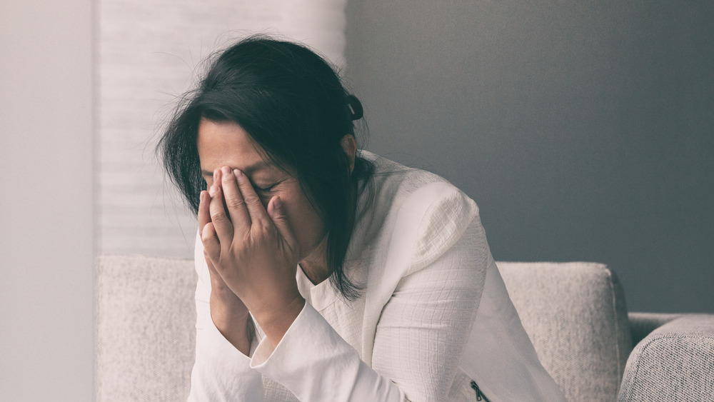 A woman crying with her face in her hands 