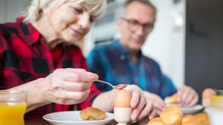 mature couple eating breakfast featuring boiled eggs