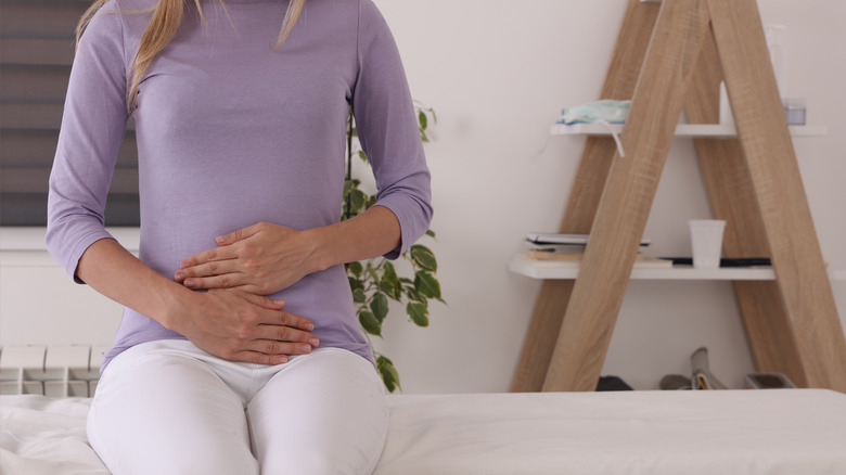 woman holding pelvic area