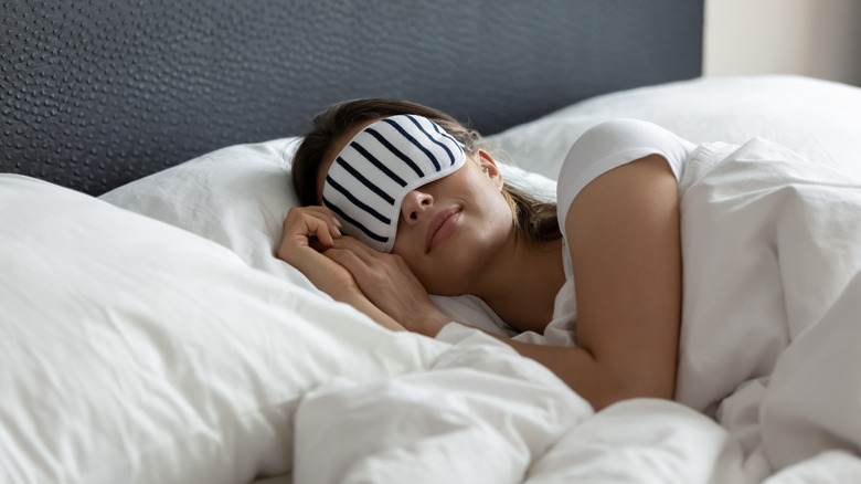 A young woman sleeps comfortably in bed