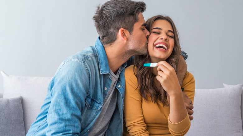 couple holding pregnancy test in hands