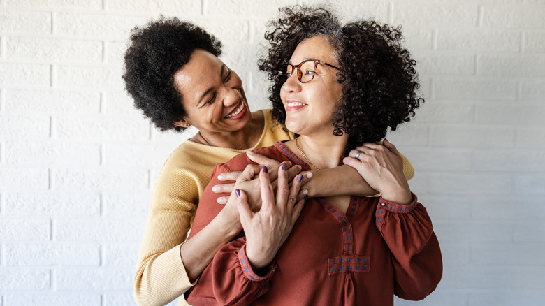 Smiling lesbian couple hugging