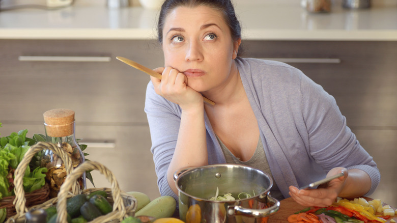 woman wondering about what to cook in kitchen
