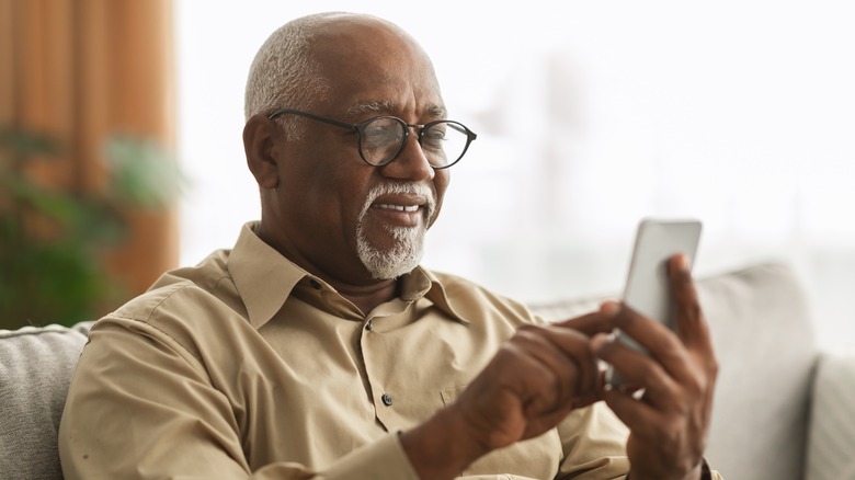 Smiling older man using smartphone