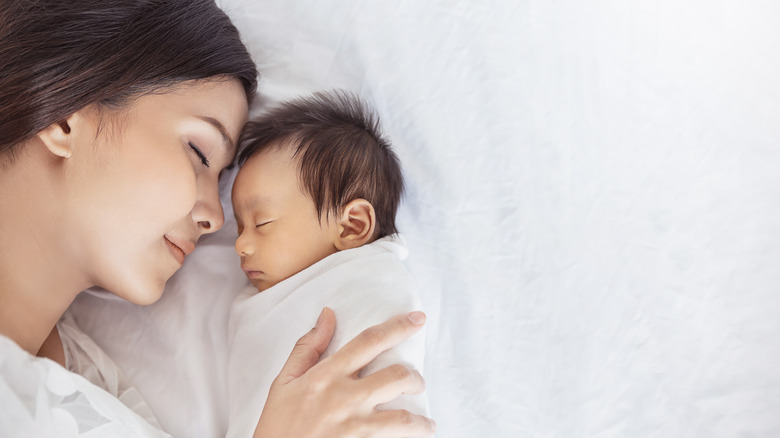 A woman and her baby sleep together