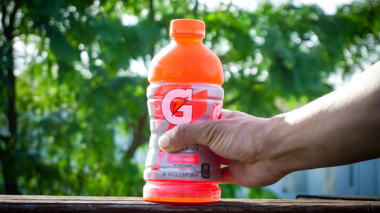 Man holding Gatorade on table