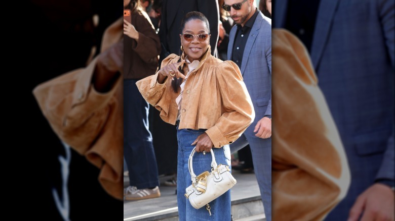 Oprah Winfrey at an awards event dressed in a tight black dress