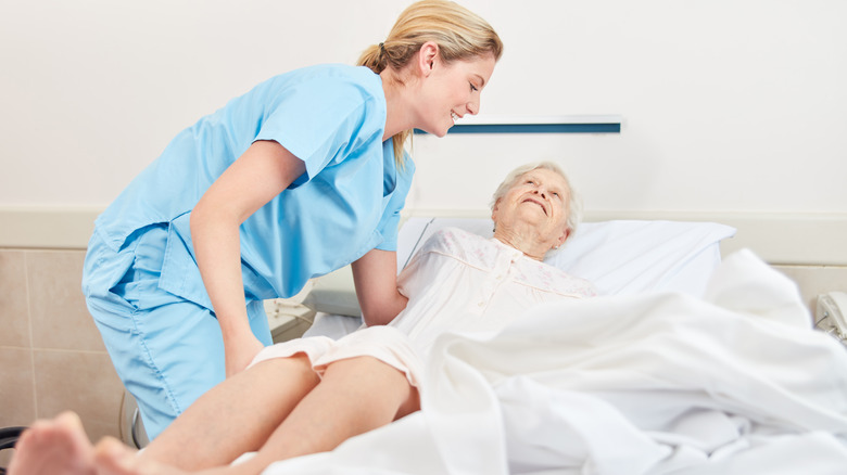 Nurse assisting patient in bed