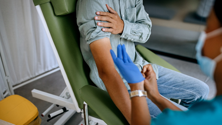 Patient rolling up sleeve