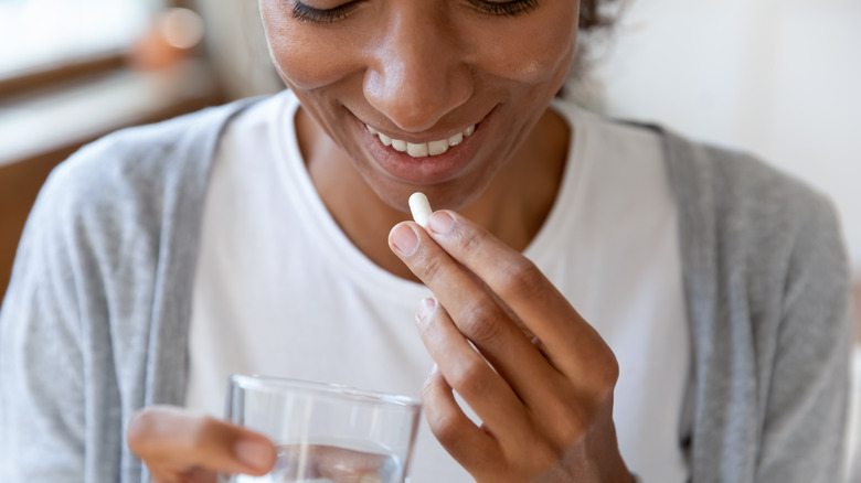 A woman takes a probiotic supplement