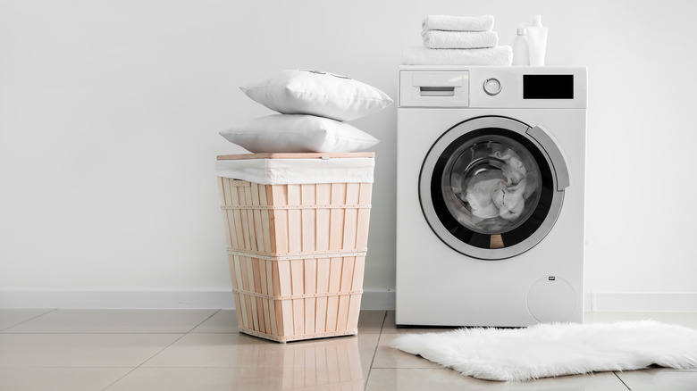 pillows and hamper beside washing machine