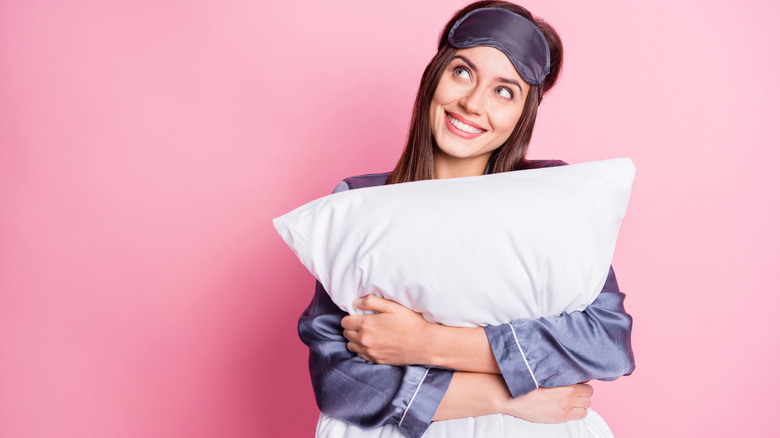 woman holding her pillow and thinking 