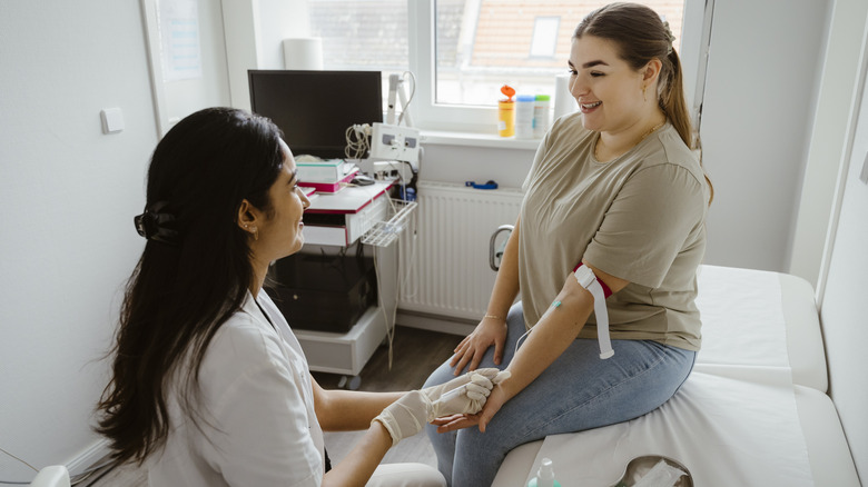 young woman getting blood drawn by medical staff