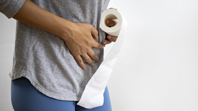 person holding toilet paper roll