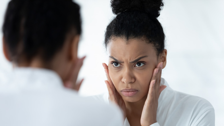 Woman looking at reflection in mirror