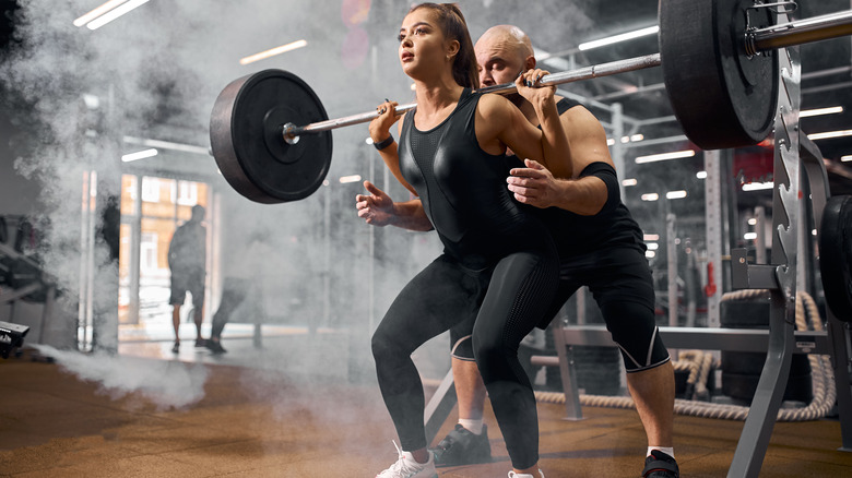 a woman performing back squats 