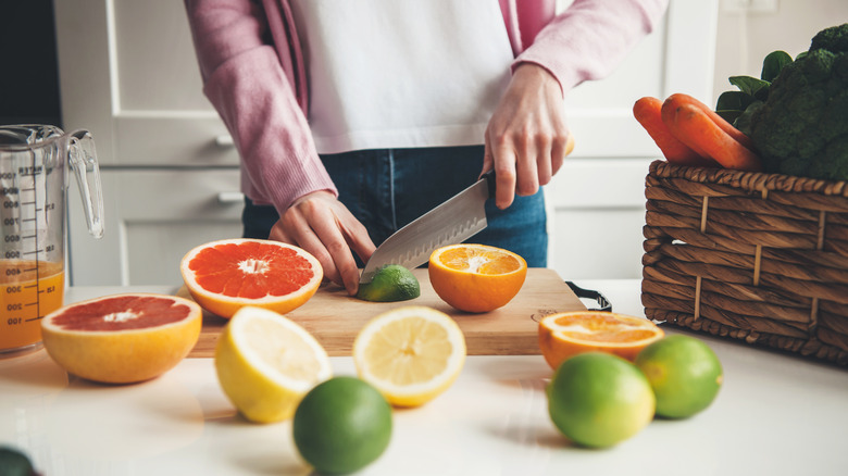 woman cutting citrus fruit