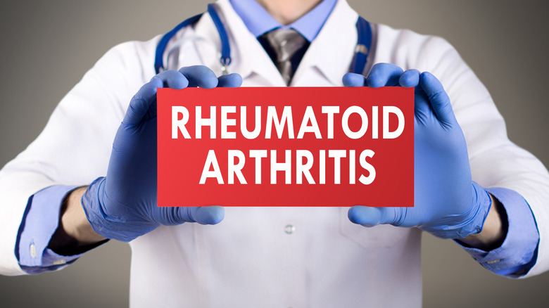 Doctor holding sign that says "rheumatoid arthritis"