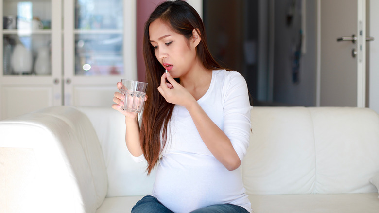 Pregnant woman holding pills