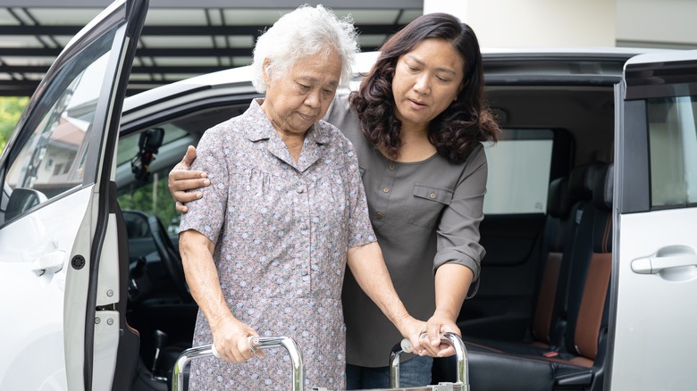woman helping an older woman out of the car