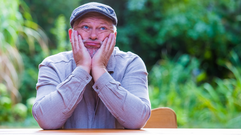 man looks bored sitting at the table 