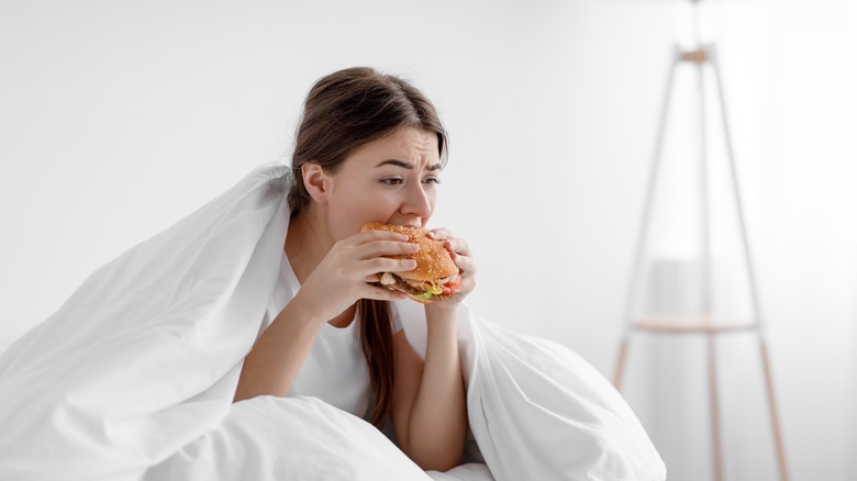 Woman sitting in bed and eating 
