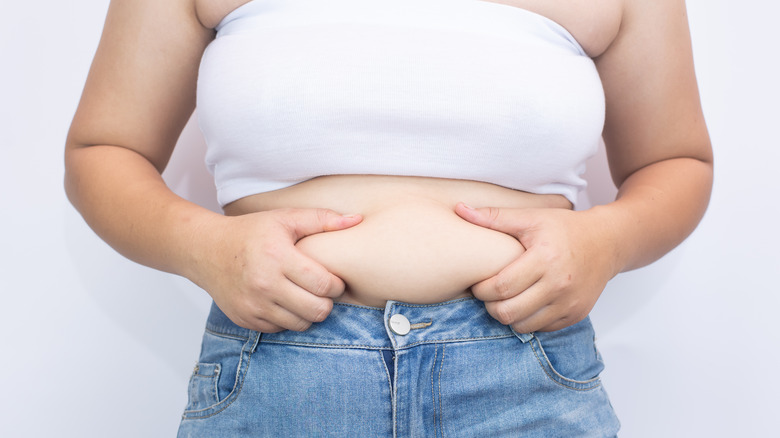 woman squeezing belly fat