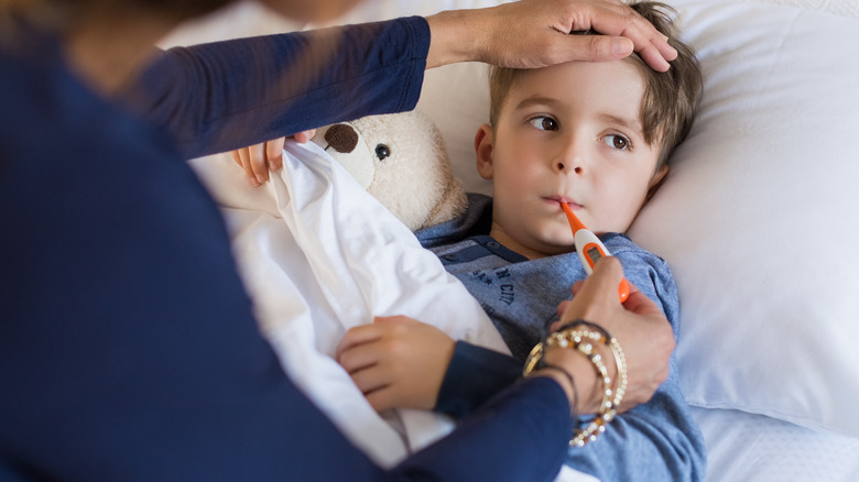 Sick boy having his temperature taken