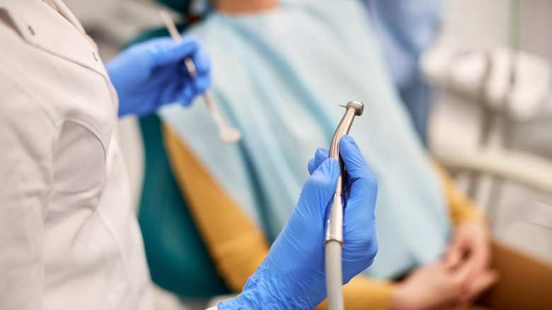 Dentist hands holding dental tools