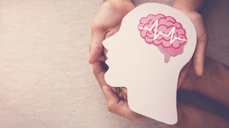 Cutout of head with illustration of brain waves
