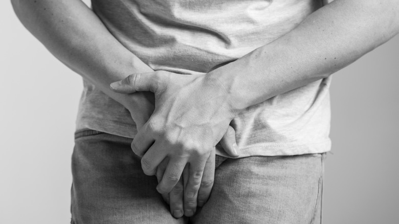 person holding in urine