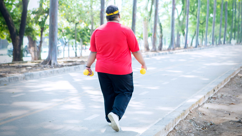 an overweight man walking in the park