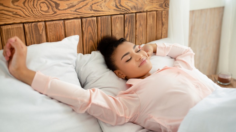 Black woman stretching in bed