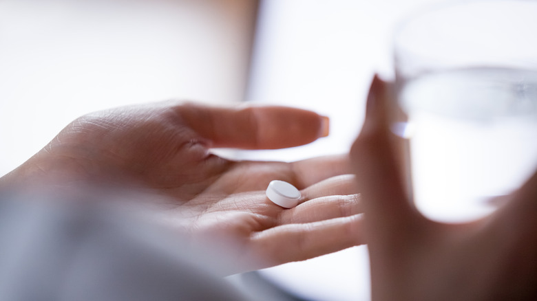 woman holding pill with water