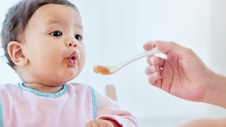 Hand feeding child baby food