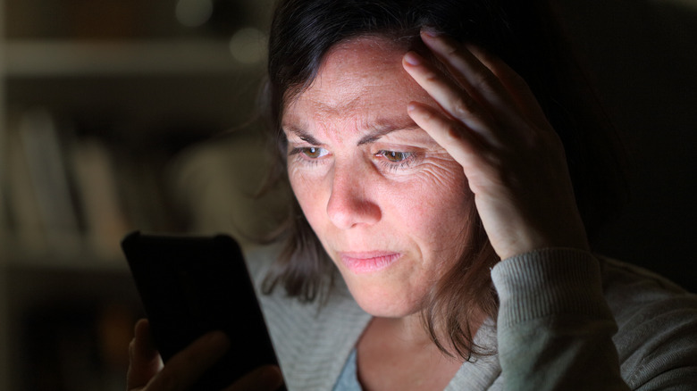 stressed woman looking at phone