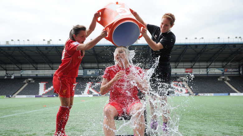 female soccer players drop ice bucket on a fellow player