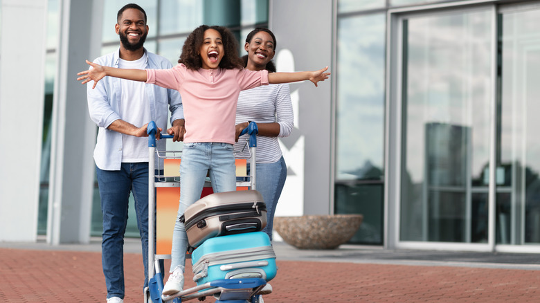 a family walking with their luggage