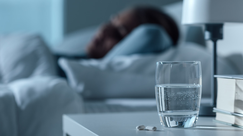 Medications on nightstand next to sleeping person