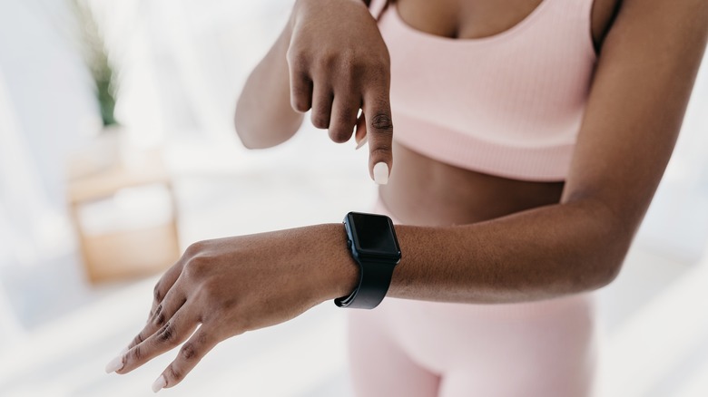 Hand pointing to fitness tracker on wrist
