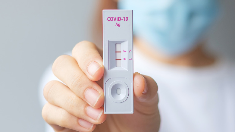 Close up of a person's hand as they hold out a COVID test