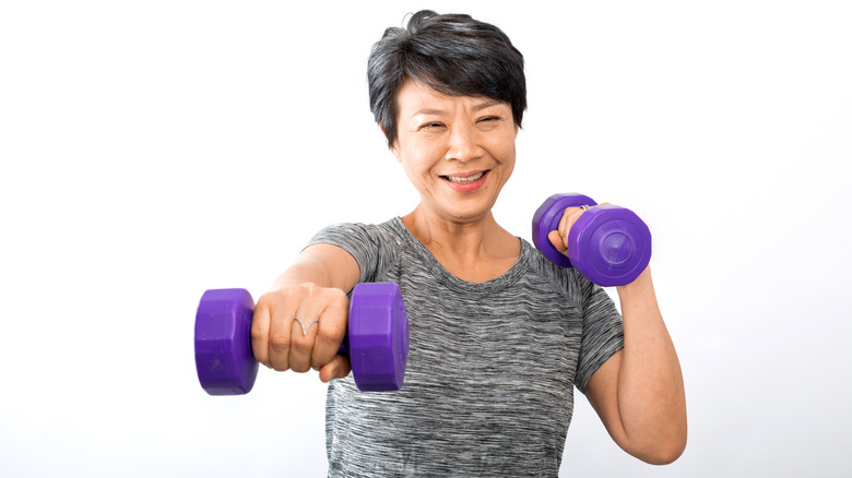 older woman using dumbbells 