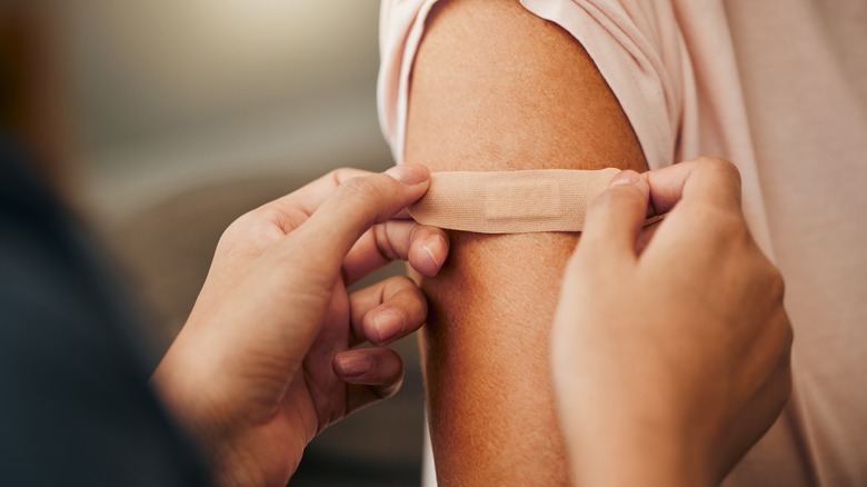Placing band-aid on arm