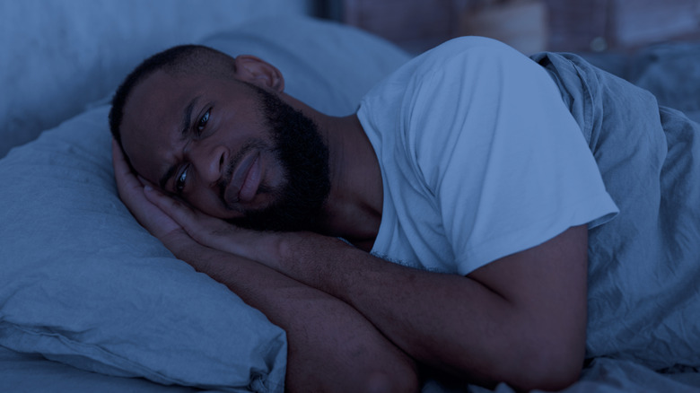Frustrated man laying in bed