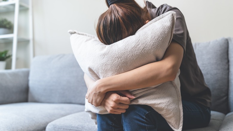 woman holding pillow over face