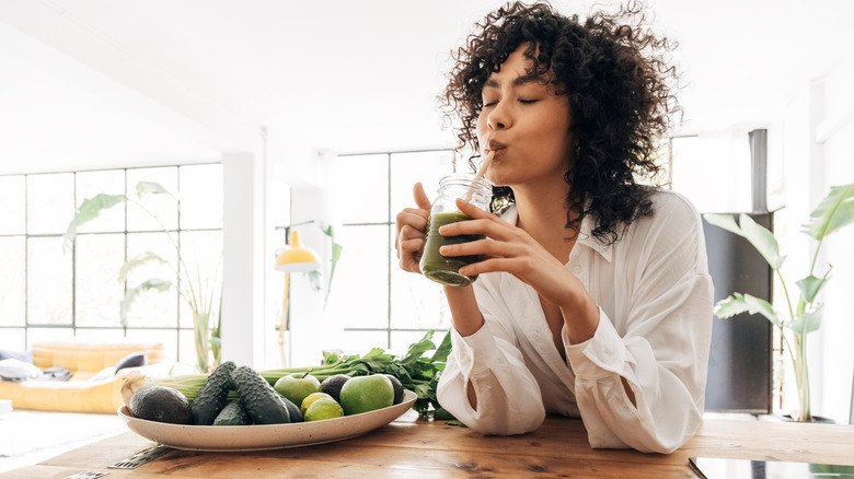 woman drinking green smoothie