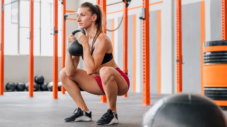 fit woman doing a goblet squat in the gym